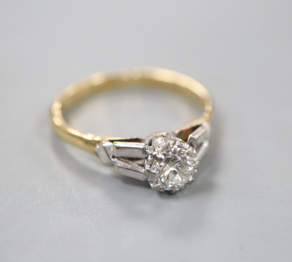 An 18ct and solitaire diamond set ring, in a raised setting, size O, gross weight 3.3 grams.